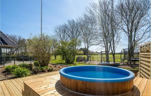 um deque de madeira com uma grande piscina azul num pátio de madeira em 6 Bedroom Stunning Home In Spttrup em Spottrup