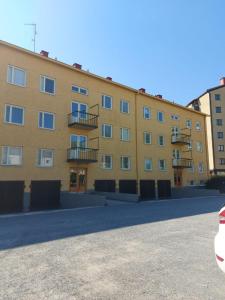 a large yellow building with a lot of windows at Kiertokatu apartment in Pori