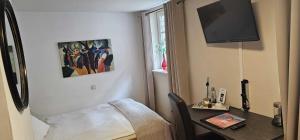 a room with a table and a bed and a television at Hotelbetriebe Güldenhaupt GmbH in Arnsberg