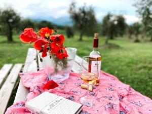 una mesa de picnic con una botella de vino y flores en Agriturismo Fioralba, en Polpenazze del Garda
