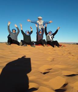 een groep mensen in de woestijn bij Merzouga Tours in Merzouga