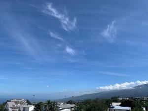 uma vista para um céu azul com montanhas ao fundo em Studio cosy - Situé au Tampon em Le Tampon