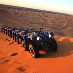 een groep atvs rijden in de woestijn bij Merzouga Tours in Merzouga