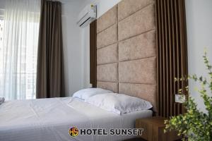 a hotel suite with a bed and a large window at Hotel SUNSET Shengjin in Shëngjin