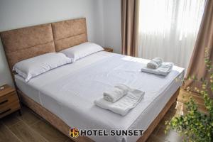 um quarto com uma cama com toalhas em Hotel SUNSET Shengjin em Shëngjin