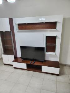 ein Wohnzimmer mit einem Flachbild-TV an der Wand in der Unterkunft Rana's apartment in Amman