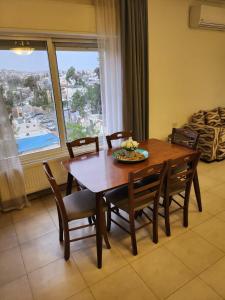 einen Holztisch und Stühle in einem Zimmer mit Fenster in der Unterkunft Rana's apartment in Amman