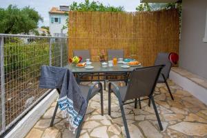 a patio with a table and chairs on a balcony at Porto Gaios House in Gaios