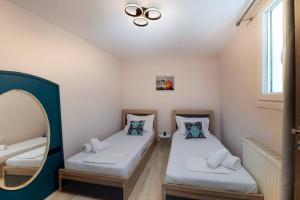 a small room with two beds and a mirror at Porto Gaios House in Gaios