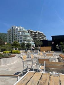 a row of tables and chairs with buildings in the background at Family Residence Petrovac in Petrovac na Moru