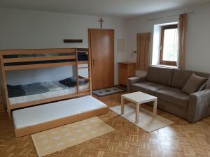 salon z kanapą i łóżkami piętrowymi w obiekcie Schöne Wohnung am Bauernhof 
