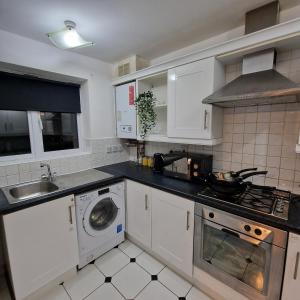 a kitchen with a sink and a washing machine at Pet Friendly 3 Bedroom Apartment in Manchester by Sublime Stays in Manchester
