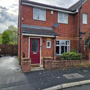 a red brick house with a red door at Pet Friendly 3 Bedroom Apartment in Manchester by Sublime Stays in Manchester