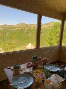 a table with plates of food and a view of a mountain at Alereks Mountain Camping in Dsegh