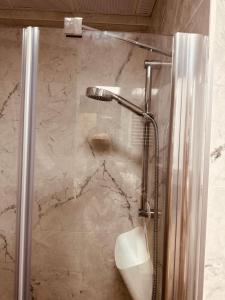 La salle de bains est pourvue d'une douche avec une porte en verre. dans l'établissement Super cool apartment with pools and gym, à Antalya