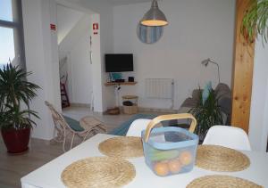 a room with a table with a basket of oranges on it at Agapito's Houses in Praia de Odeceixe