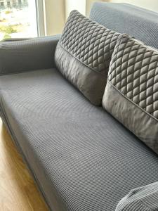 a couch with two pillows on top of it at Super cool apartment with pools and gym in Antalya