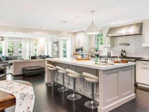 una cocina con una gran isla con taburetes de bar en Villa Southampton Village en Southampton