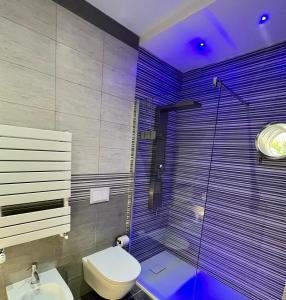 a bathroom with a toilet and a shower with purple lighting at I-relais b&b in Montefalcone del Sannio