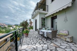 a patio with a table and chairs on a balcony at Harmony villa in Sivota