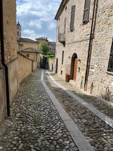 un callejón en un casco antiguo con edificios de piedra en Caolzio18 en CastellʼArquato