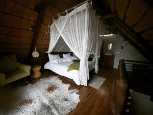 a bedroom with a bed with a net canopy at Von Bach Dam Resort in Okahandja