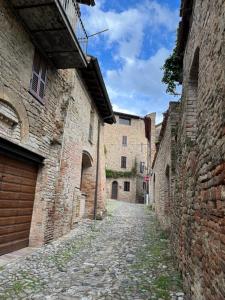 un callejón en un casco antiguo con edificios de piedra en Caolzio18 en CastellʼArquato