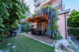 a garden with a wooden deck with a table and flowers at H11 COUNTRY LUX - Sanremo - Garden in Sanremo