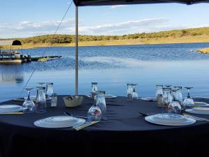 una mesa con vasos y platos sobre el agua en Von Bach Dam Resort, en Okahandja