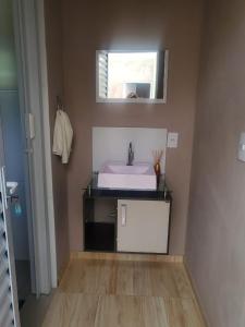 a bathroom with a sink and a mirror at Pousada Doce Lar in Itatiba