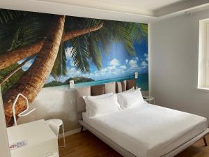una camera da letto con un murale di palme sul muro di I-relais b&b a Montefalcone del Sannio
