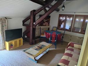 a living room with a couch and a table and a tv at Abondance in Valdeblore