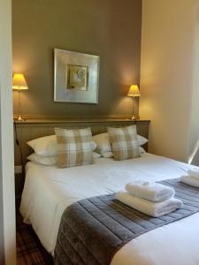 a bedroom with a large white bed with two pillows at The Church House in Torver