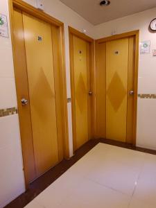 um quarto vazio com três portas e piso em azulejo em 香港太阳宾馆 em Hong Kong