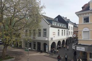 Eine Straße in einer Stadt mit Leuten, die auf der Straße spazieren in der Unterkunft Hotel Freye in Rheine