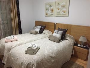 um quarto com 2 camas e toalhas em Cabanas2stay em Cabanas de Tavira