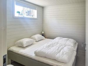 een bed met 2 kussens in een kamer met een raam bij Holiday home ROCKNEBY IV in Rockneby