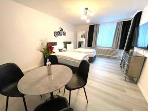 a hotel room with a bed and a table and chairs at Park-Residenz Isernhagen in Hannover