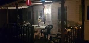 a table and chairs on a porch at night at Splendide mobil-home in Narbonne