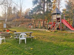 um parque infantil com uma mesa e cadeiras e um escorrega em Holiday home MUNSö em Ekeby