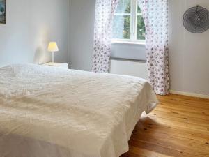 1 dormitorio con cama y ventana en Holiday home MUNSö en Ekeby