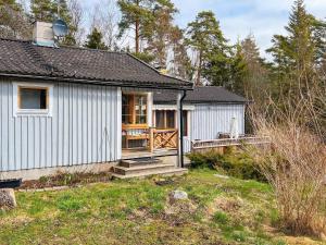 EkebyにあるHoliday home MUNSöのポーチとデッキ付きの小さな白いコテージ