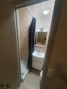 y baño con lavabo, aseo y espejo. en Hôtel de Choisy en París