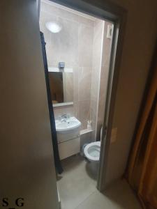 La petite salle de bains est pourvue de toilettes et d'un lavabo. dans l'établissement Hôtel de Choisy, à Paris