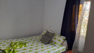 a bed with polka dot pillows in a room at LNIMMO - DEPOU - Studio meublé Ahmadou Ekie climatisé et avec internet illimité avec forage in Yaoundé