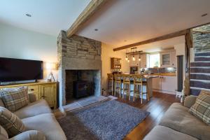 a living room with a couch and a fireplace at Chimney Cottage in Holmfirth