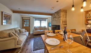 a living room with a couch and a table with wine glasses at Chimney Cottage in Holmfirth