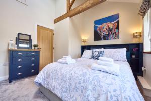 a bedroom with a blue and white bed and a tv at Chimney Cottage in Holmfirth