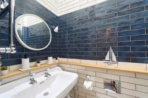 a bathroom with a sink and a sailboat on the wall at Chimney Cottage in Holmfirth +25 photos