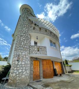 un edificio con una torre con puertas de madera en Къща за гости Замък Никола en Shtarkelovo Gnezdo